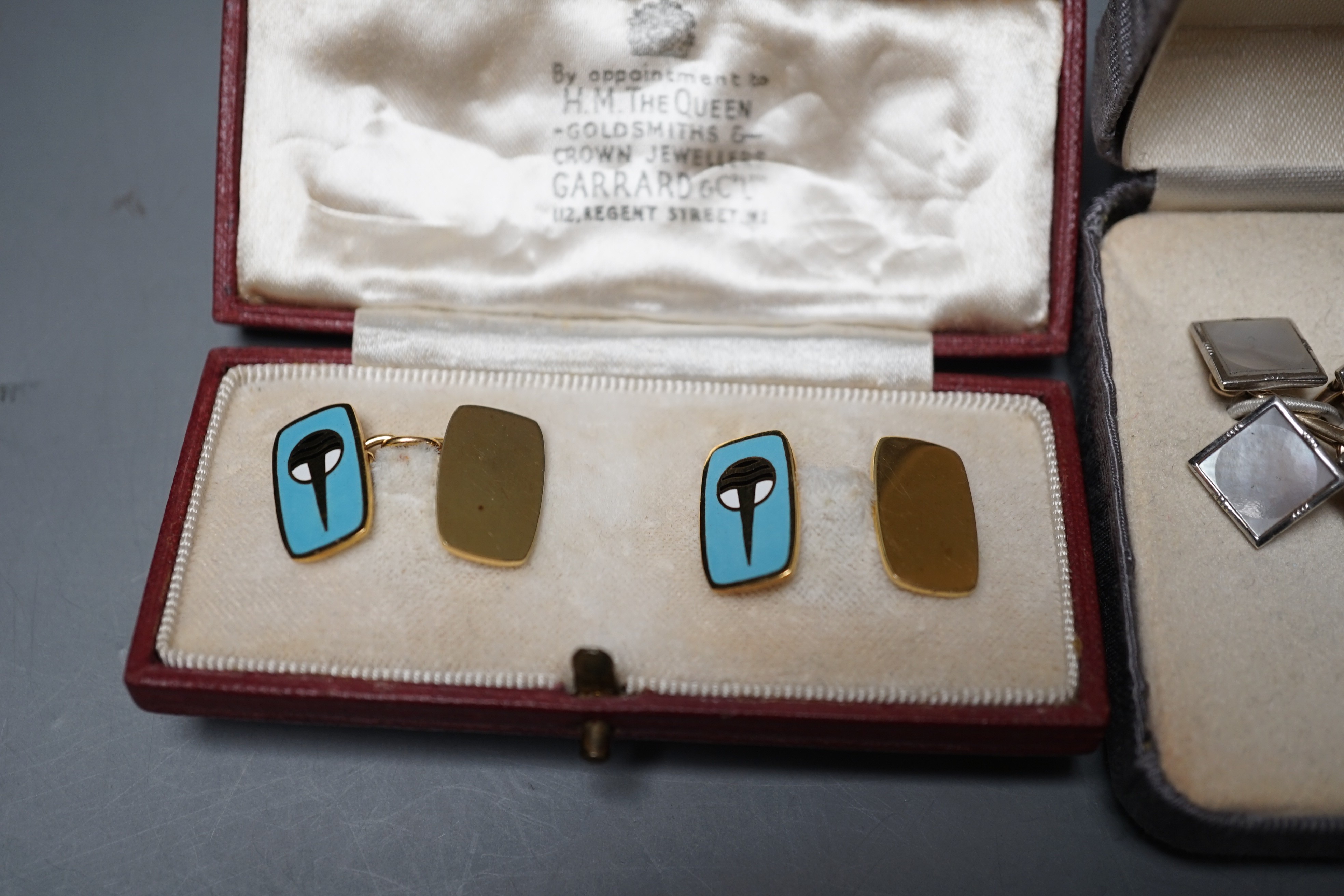 A cased pair of Garrard & Co 9ct gold and enamelled cufflinks, length 16mm, gross weight 7.8 grams, one other pair of 9ct gold and mother of pearl set cufflinks and a pair of 18ct gold oval cufflinks, 7.2 grams.